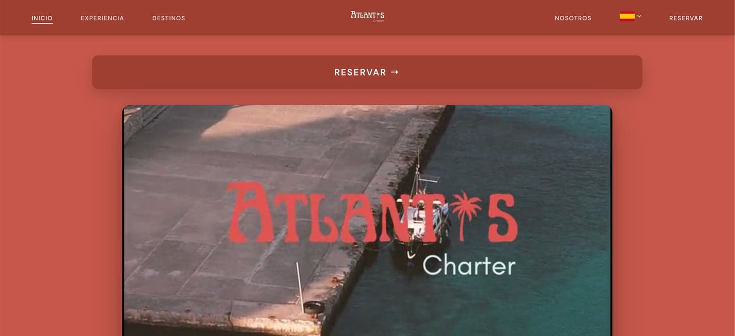 Startseite der Website von Atlantis Charters mit der Buchungsschaltfläche über einem Video des Boots, das an einer Steinmole festgemacht ist